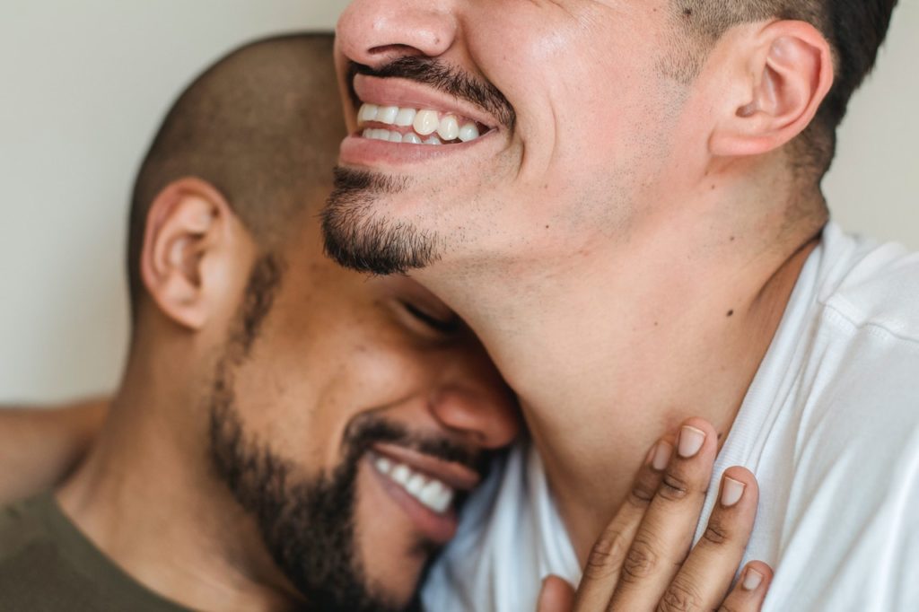 A happy LGBTQ+ couple embracing each other.